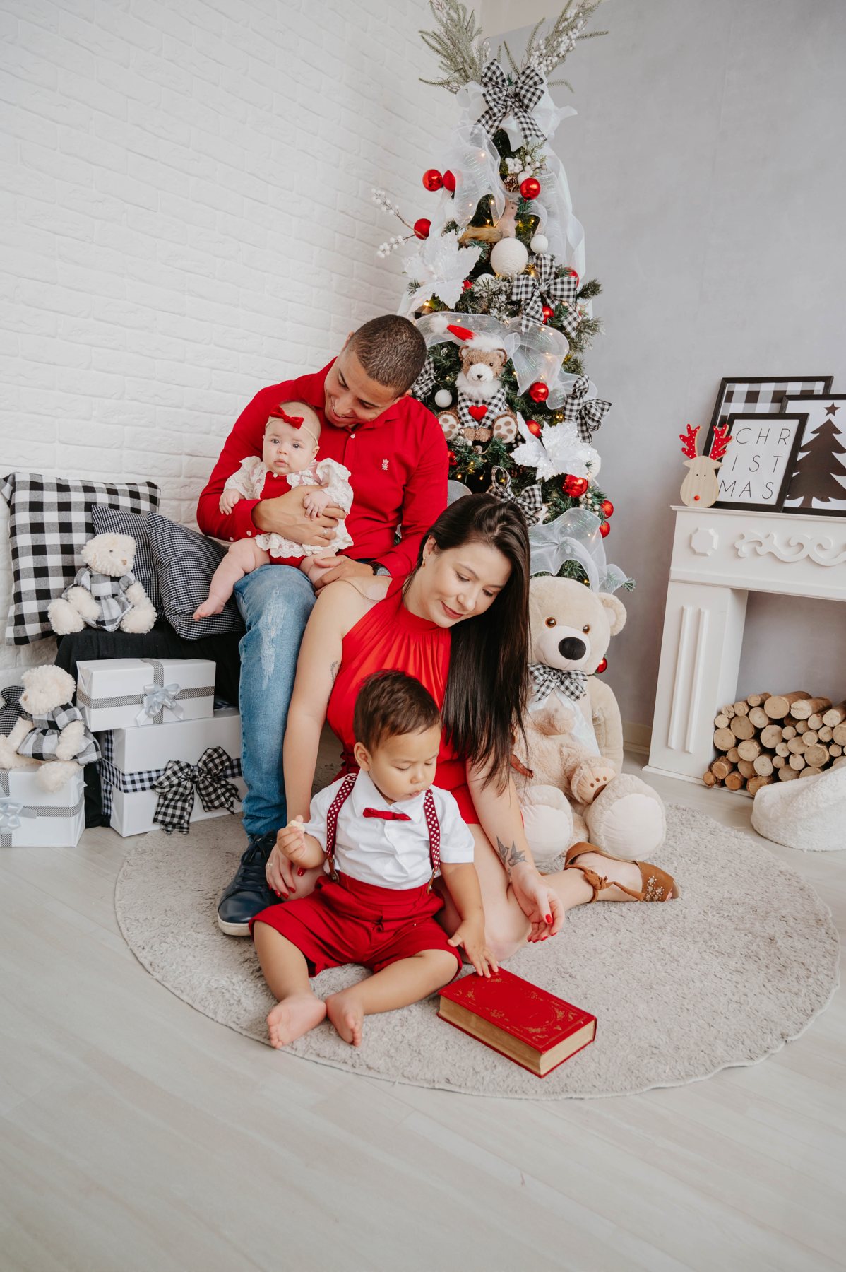 Família reunida ao lado de uma árvore de Natal