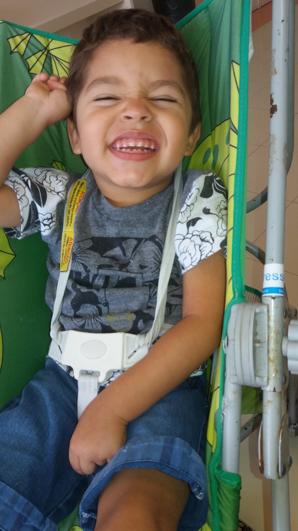 Pedrinho sentado, sorrindo para a câmera